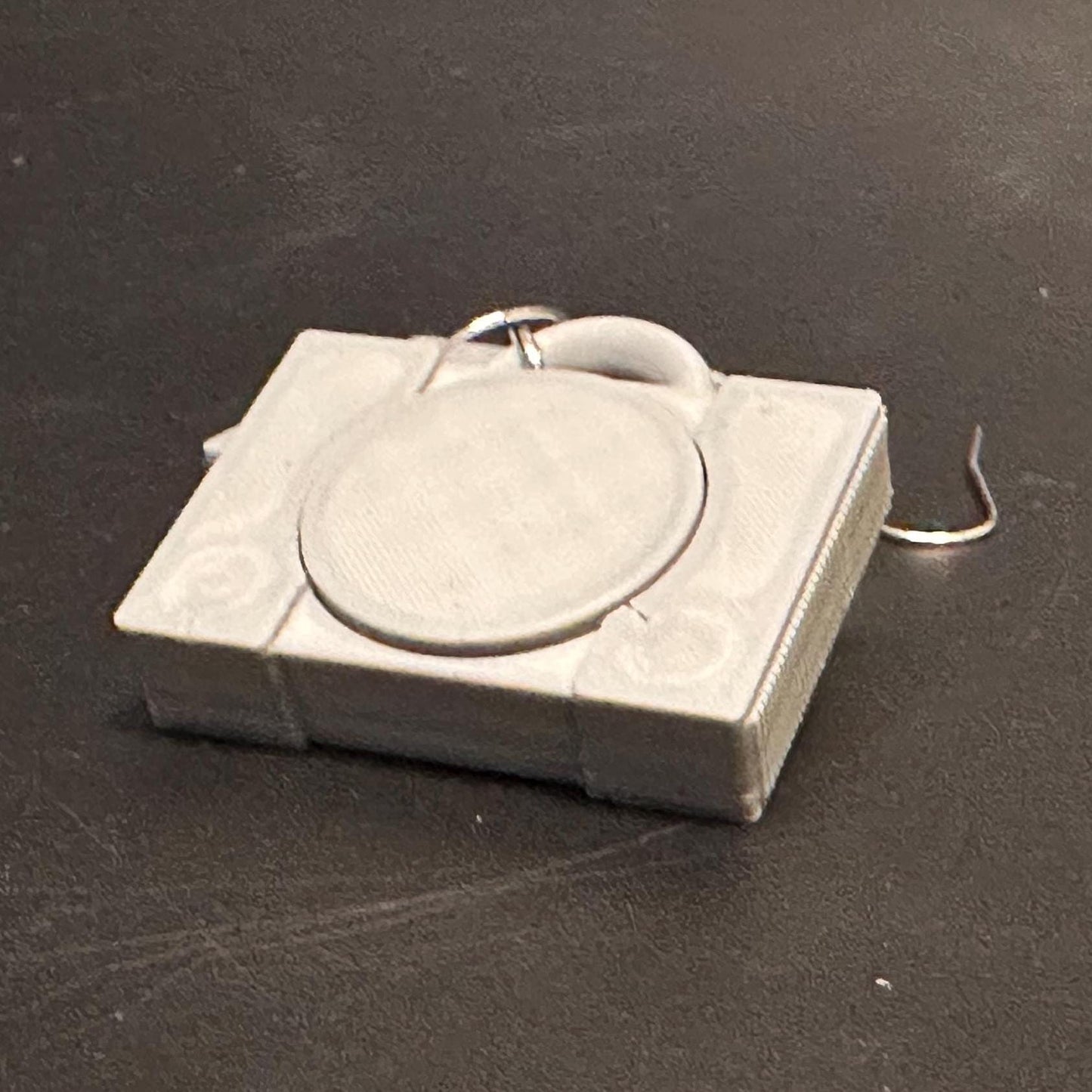 PS1 console-inspired earrings with a sleek retro design, celebrating gaming nostalgia. Lightweight and perfect for gamers and vintage enthusiasts.