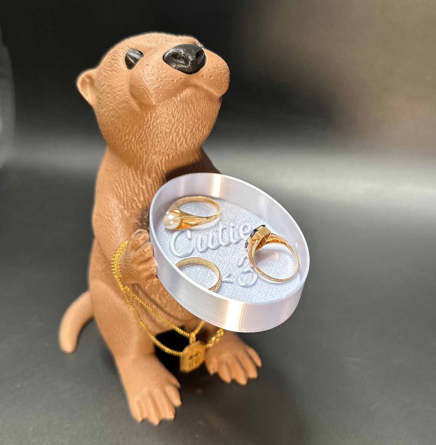 A cute otter-shaped jewelry holder with a trinket dish, available in multiple colors for added charm.
