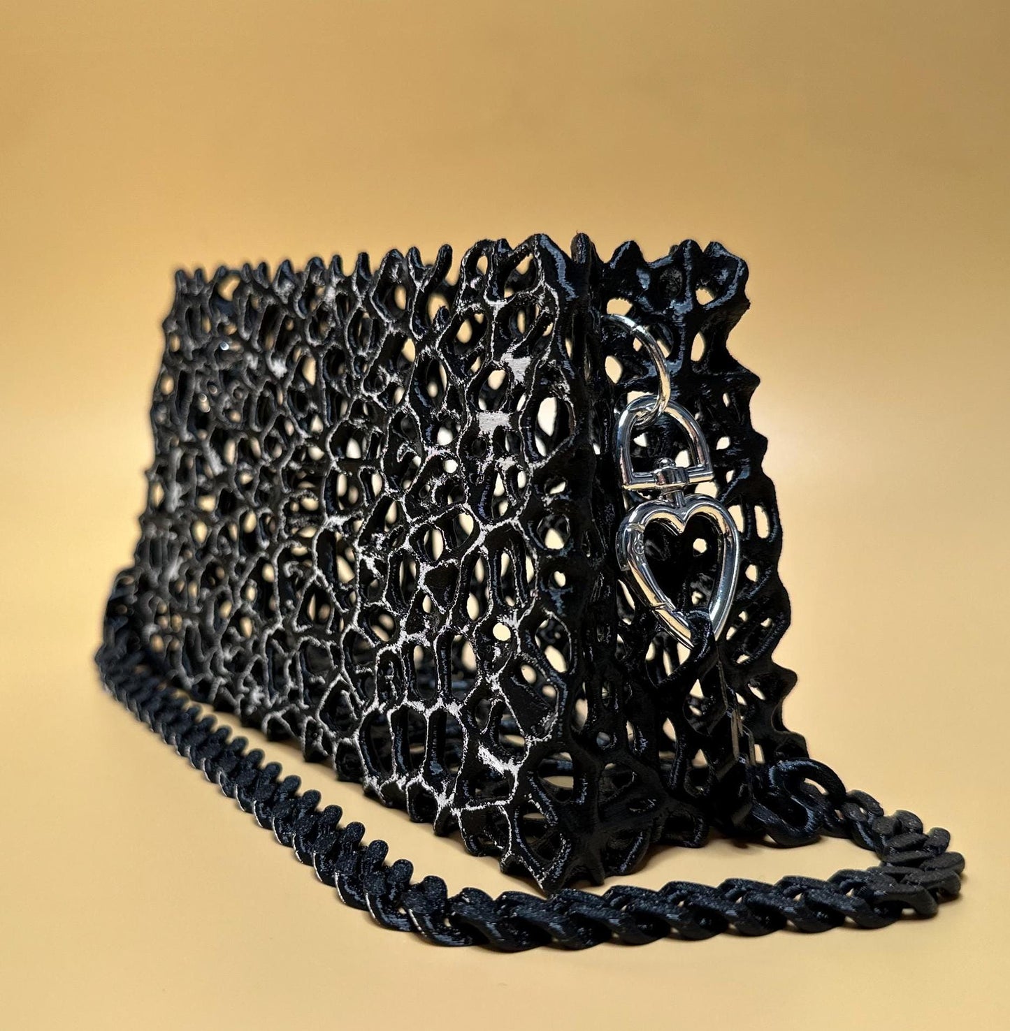 A sleek black clutch with a chain strap, suitable for gothic outfits, cosplay, or formal events.