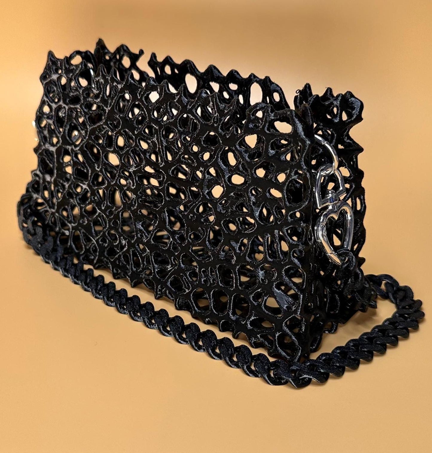 A sleek black clutch with a chain strap, suitable for gothic outfits, cosplay, or formal events.