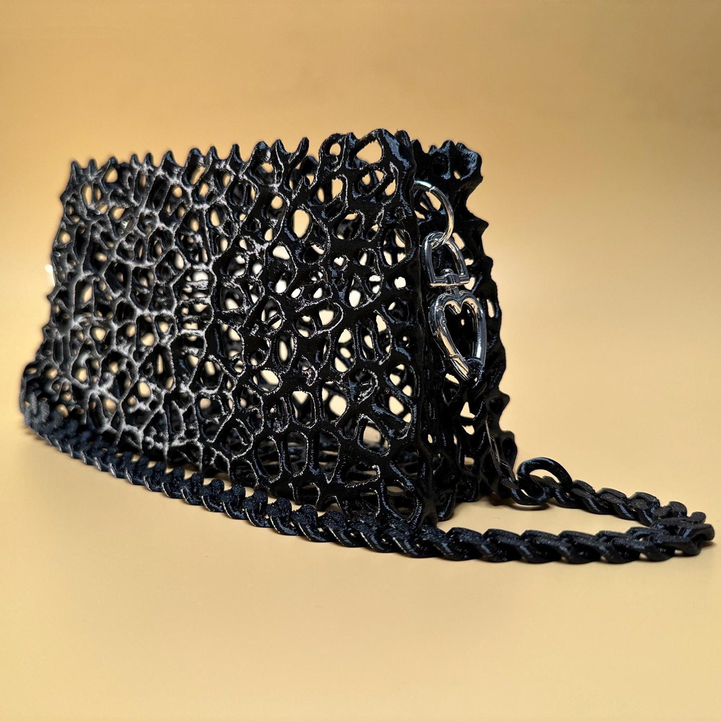 A sleek black clutch with a chain strap, suitable for gothic outfits, cosplay, or formal events.