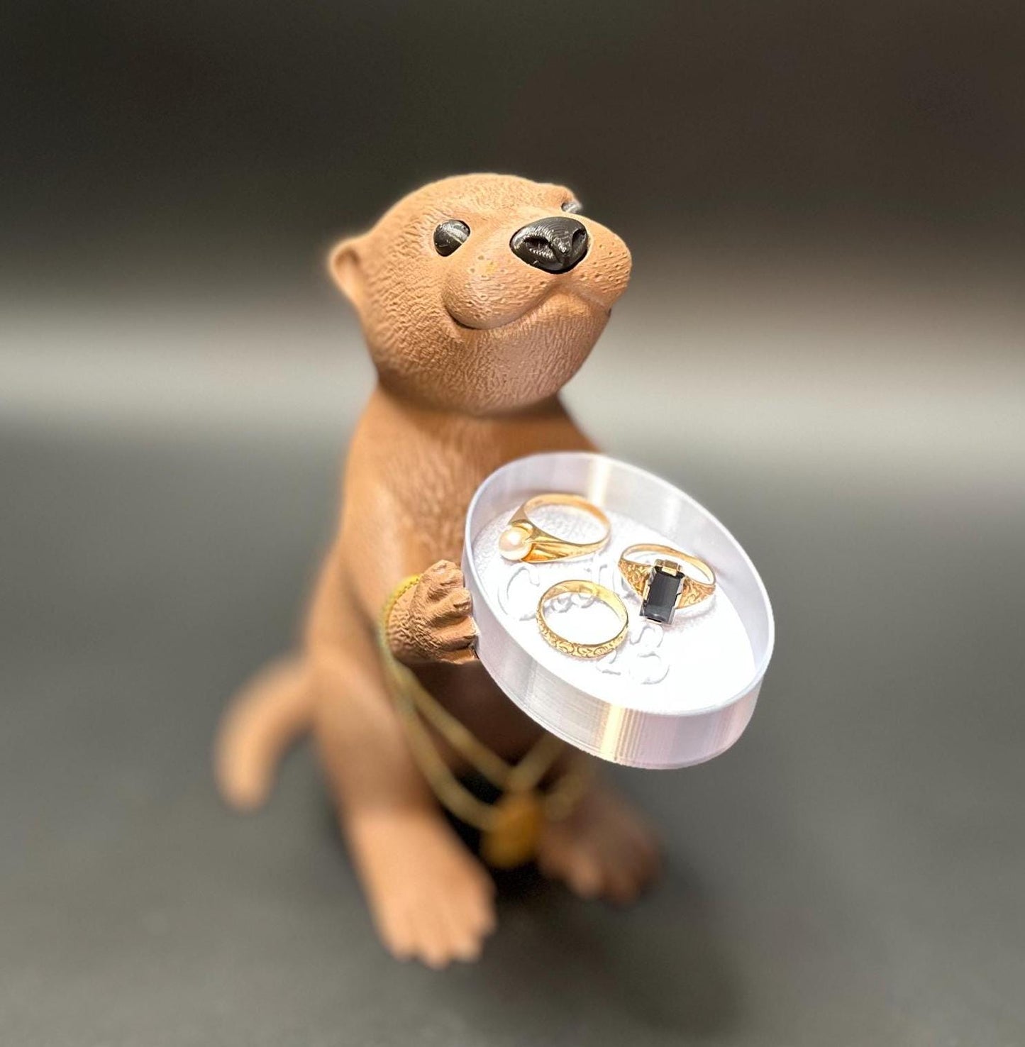 A cute otter-shaped jewelry holder with a trinket dish, available in multiple colors for added charm.