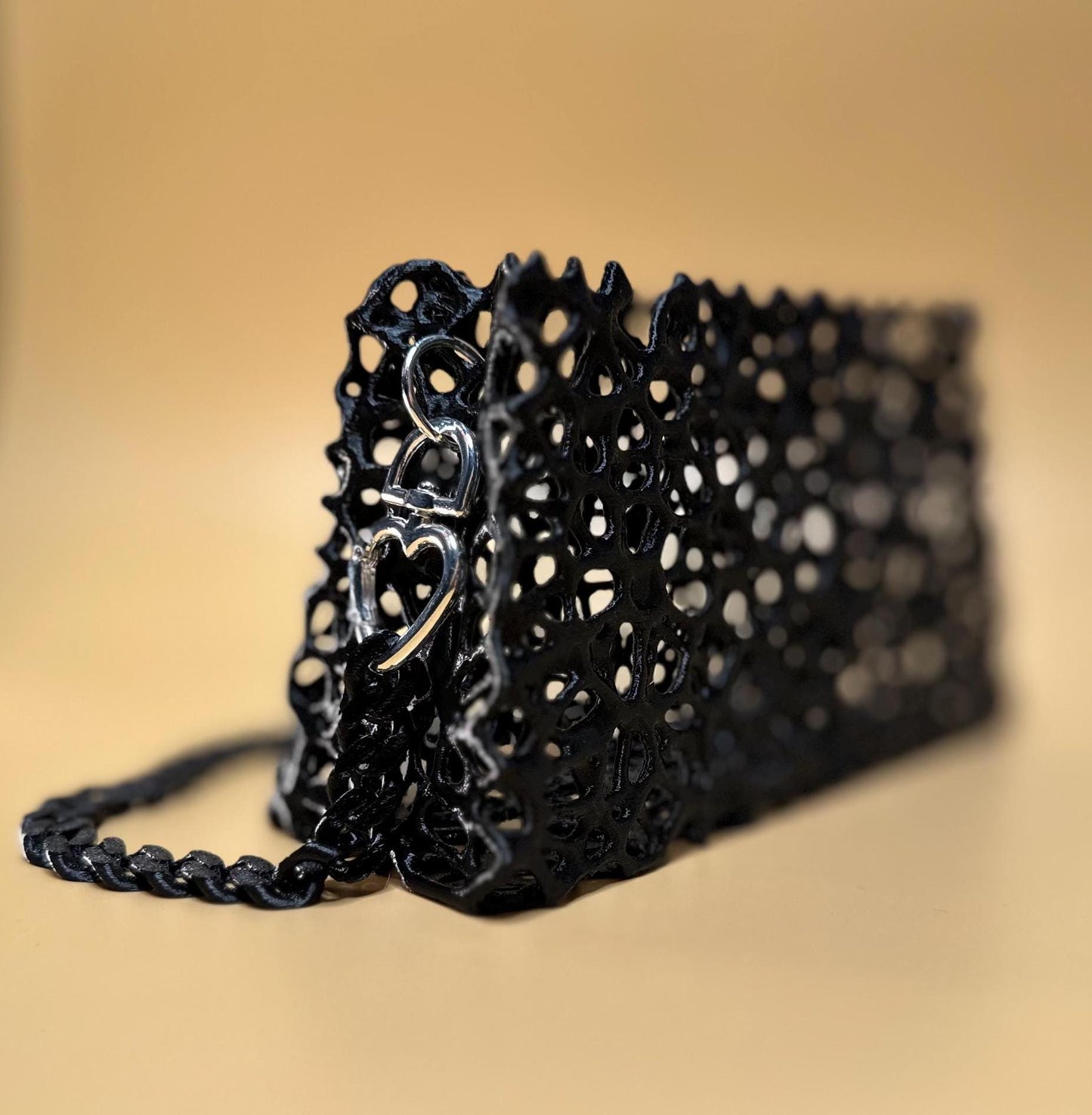A sleek black clutch with a chain strap, suitable for gothic outfits, cosplay, or formal events.