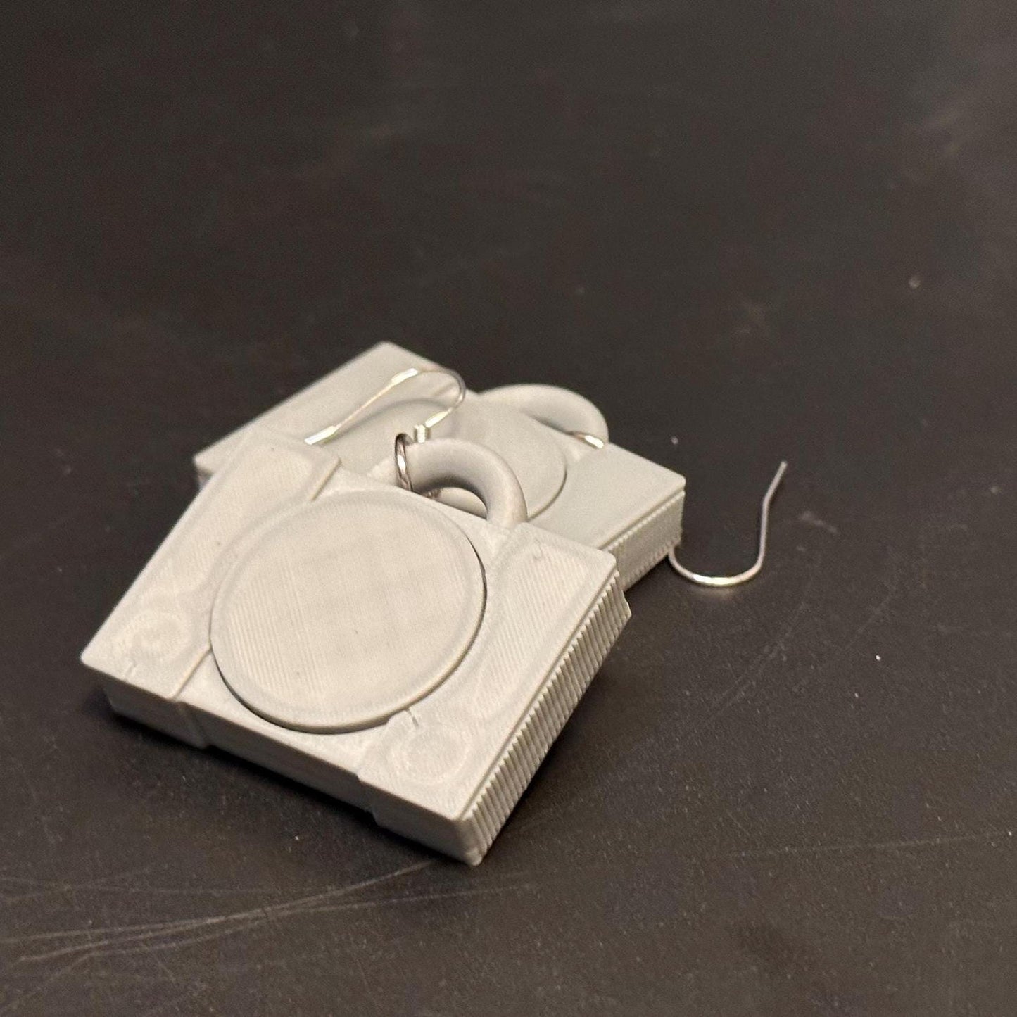 PS1 console-inspired earrings with a sleek retro design, celebrating gaming nostalgia. Lightweight and perfect for gamers and vintage enthusiasts.