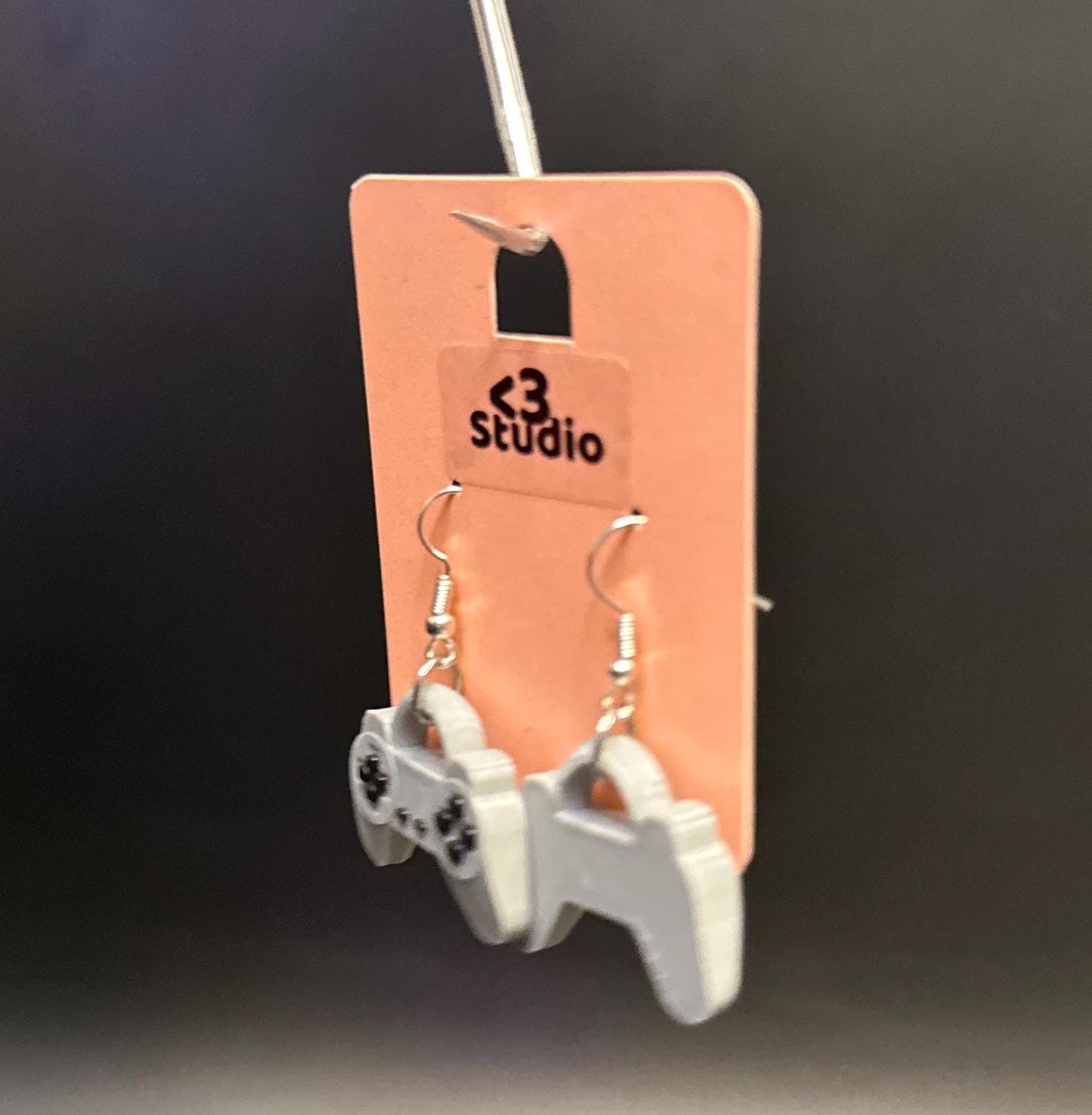 PS1 controller-inspired earrings with intricate details, perfect for gamers and retro gaming enthusiasts. Lightweight and unique design for a nostalgic touch.