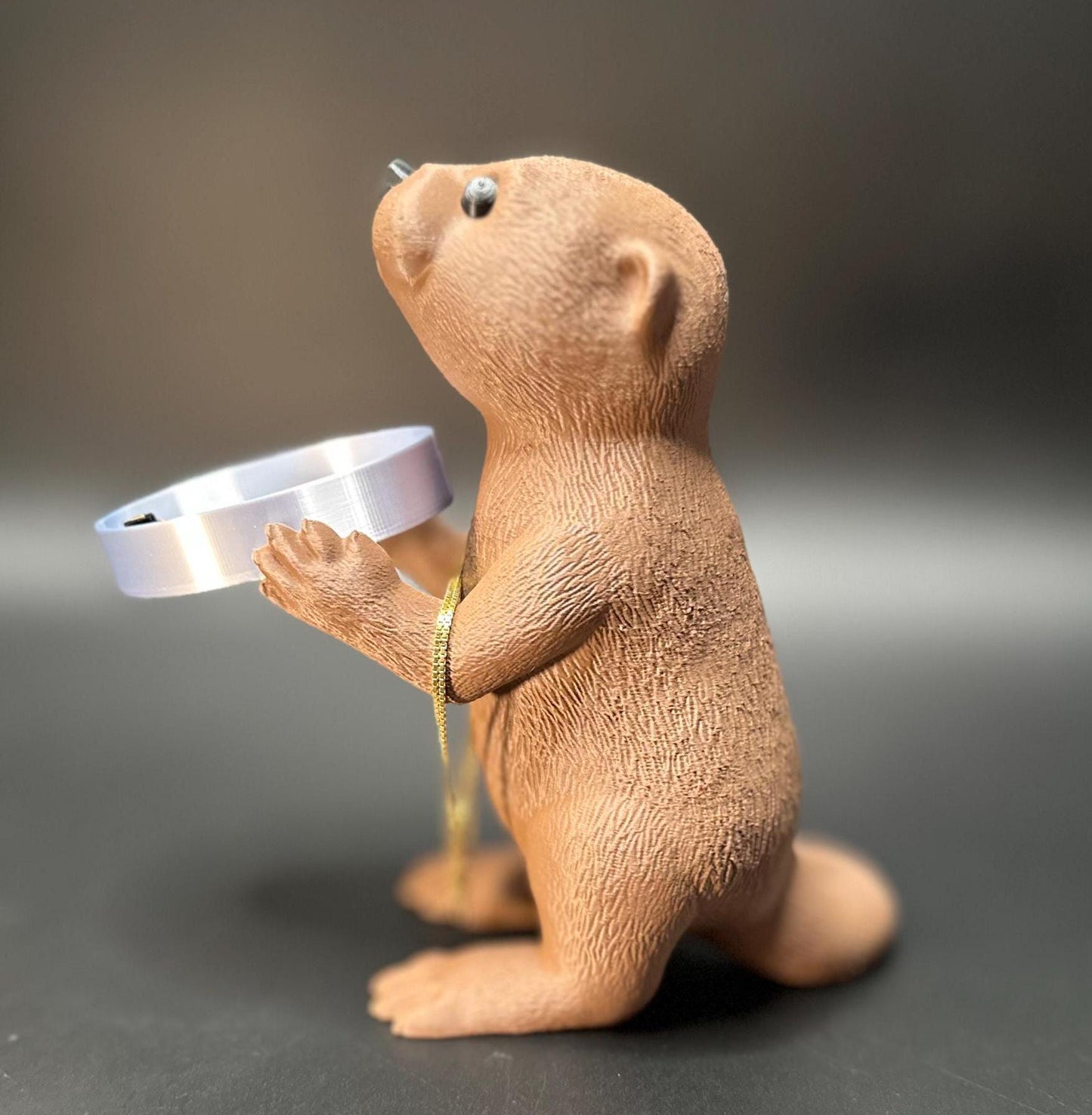 A cute otter-shaped jewelry holder with a trinket dish, available in multiple colors for added charm.