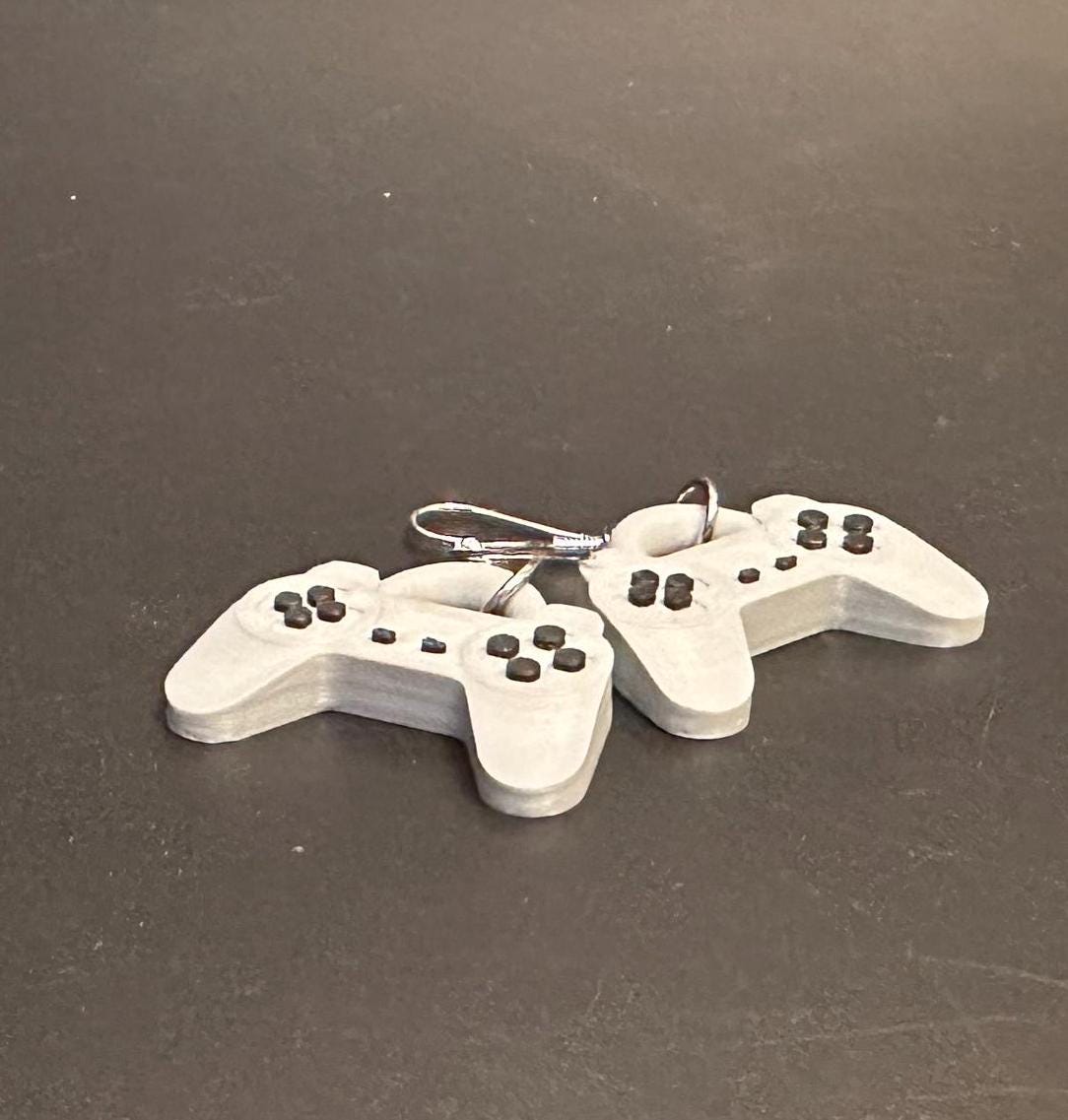 PS1 controller-inspired earrings with intricate details, perfect for gamers and retro gaming enthusiasts. Lightweight and unique design for a nostalgic touch.