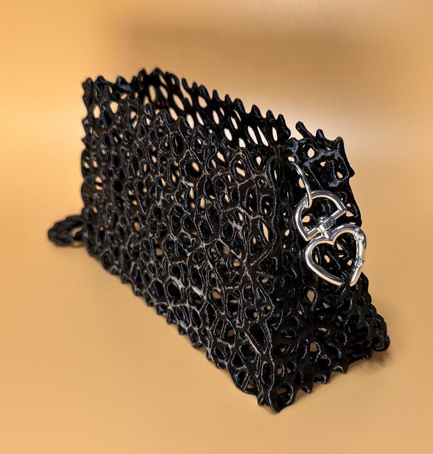 A sleek black clutch with a chain strap, suitable for gothic outfits, cosplay, or formal events.