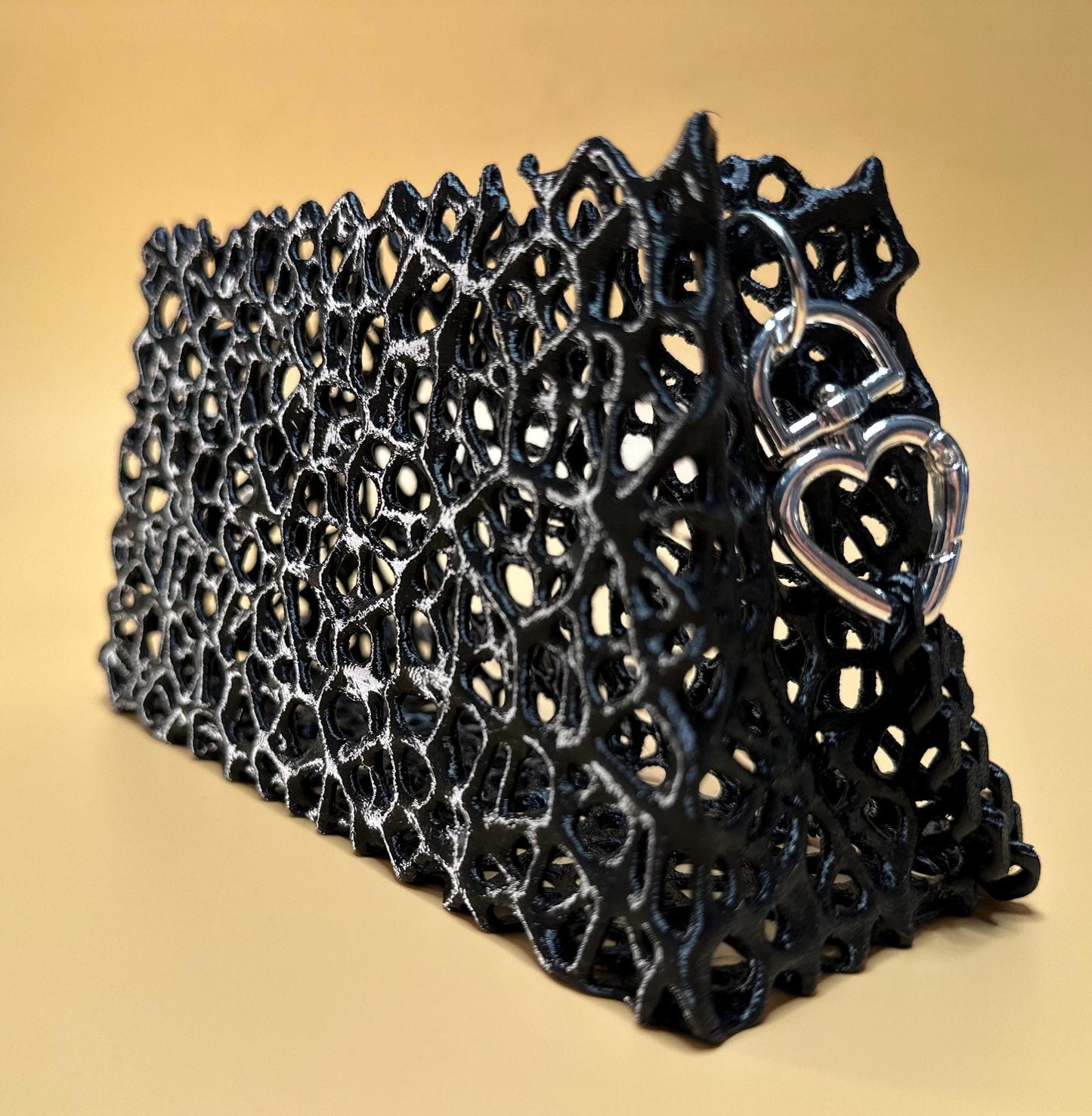 A sleek black clutch with a chain strap, suitable for gothic outfits, cosplay, or formal events.