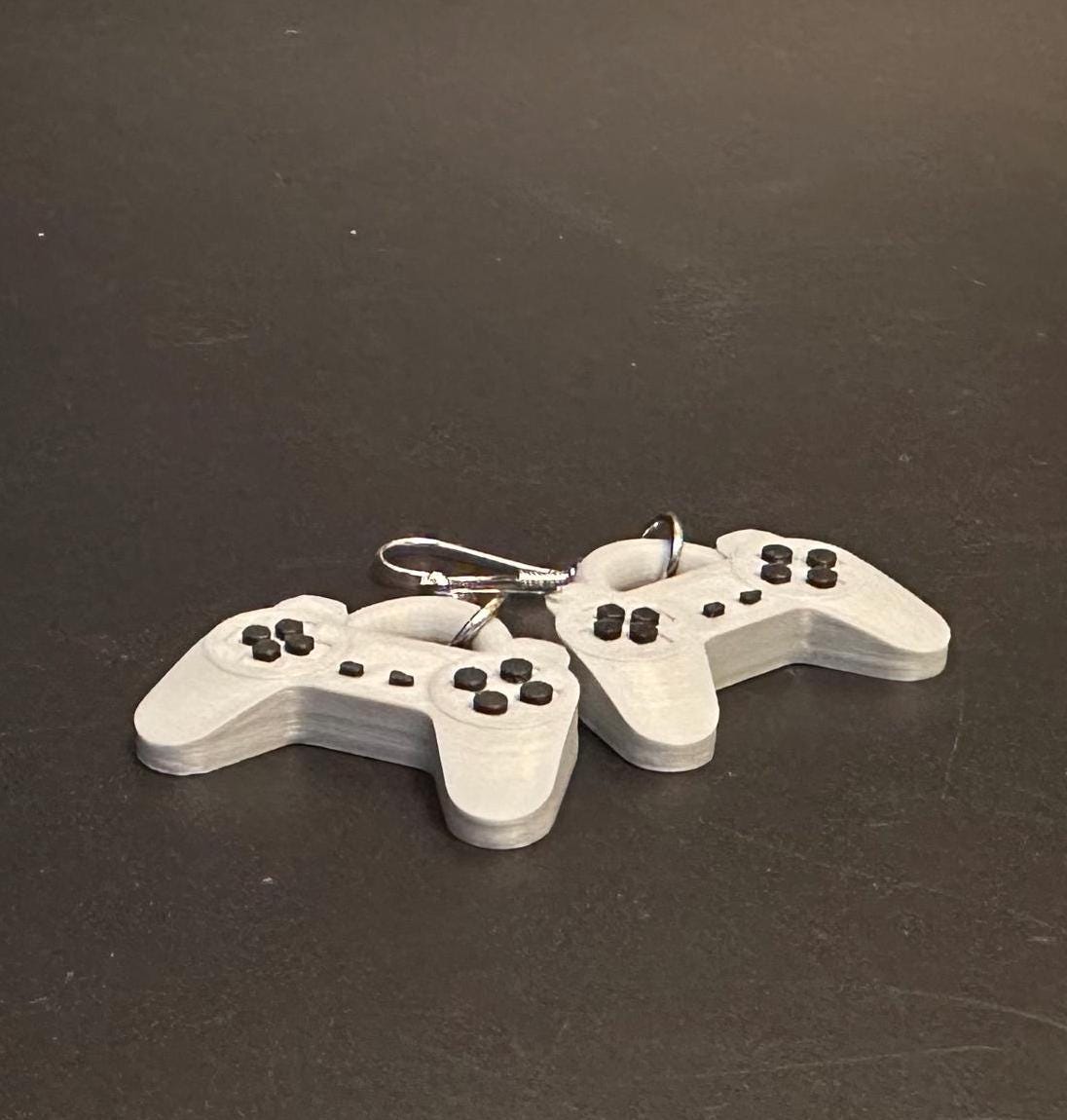 PS1 controller-inspired earrings with intricate details, perfect for gamers and retro gaming enthusiasts. Lightweight and unique design for a nostalgic touch.