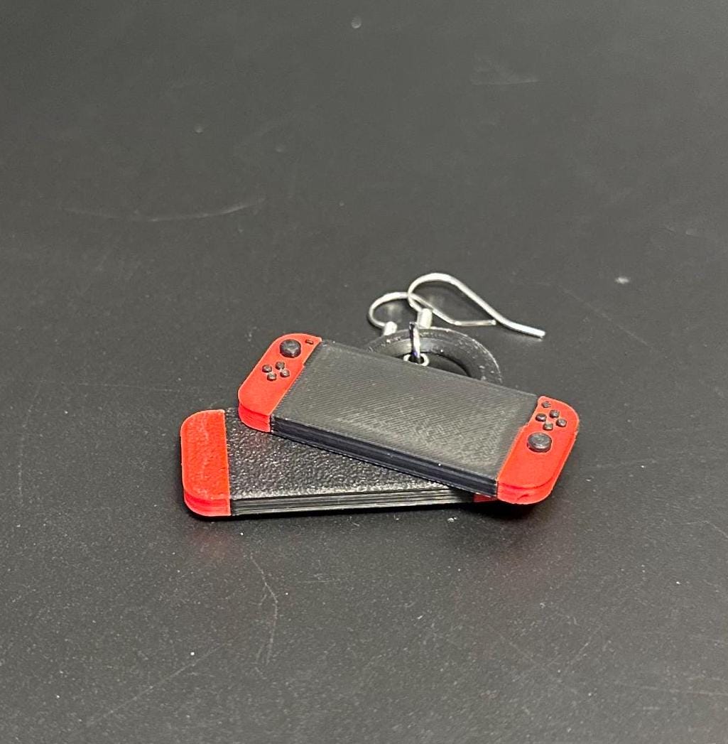 Switch-inspired console earrings with a playful and modern design, perfect for gamers seeking a fun accessory.
