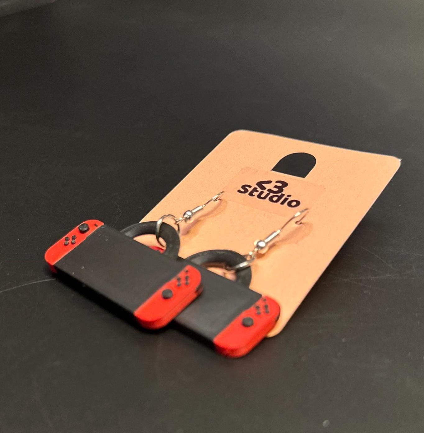 Switch-inspired console earrings with a playful and modern design, perfect for gamers seeking a fun accessory.