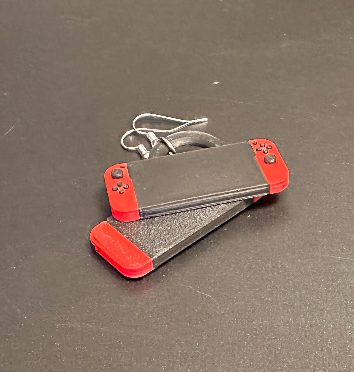 Switch-inspired console earrings with a playful and modern design, perfect for gamers seeking a fun accessory.